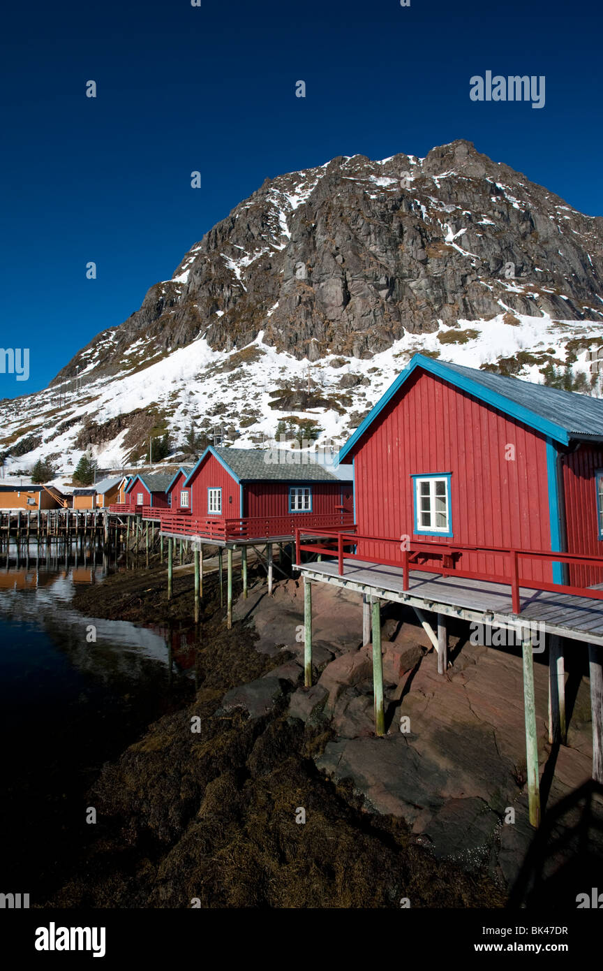 Traditional red wooden fishermen`s Rorbu huts by sea in Tind village in Lofoten Islands in Norway Stock Photo